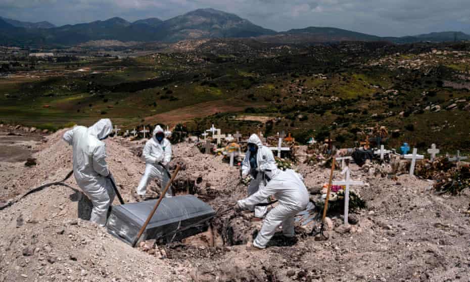 Friedhofsarbeiter, die Schutzkleidung tragen, begraben das Opfer des Coronavirus in Tijuana.