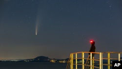Der Komet Neowise oder C / 2020 F3 wird am Dienstag, dem 14. Juli 2020, vor Sonnenaufgang über Balatonmariafurdo, Ungarn, gesehen. Er passierte am 3. Juli der Sonne am nächsten und näherte sich der Erde am nächsten 23. Juli.  (Gyorgy Varga / MTI über AP)