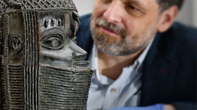 Neil Curtis, Head of Museums and Special Collections, dey wit a Benin Bronze wey dey rep di Oba of Benin für di University of Aberdeen in Schottland
