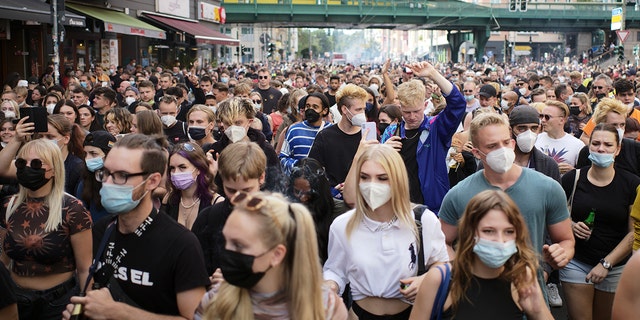Menschen, die meisten tragen Masken, tanzen hinter einem Lastwagen, während sie an einem Protest namens . teilnehmen 