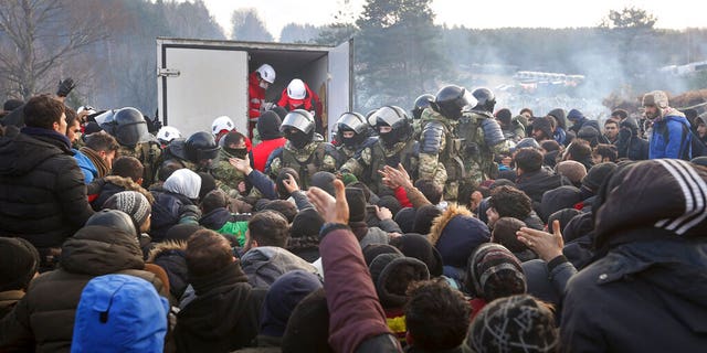 Belarussische Soldaten kontrollieren die Situation, während Migranten humanitäre Hilfe erhalten, als sie sich am Freitag, den 12.