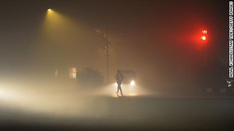 Fahrzeuge werden aufgrund einer dicken Smogschicht in der Nacht von Diwali am 4. November in Neu-Delhi, Indien, bei schlechter Sicht gefahren.