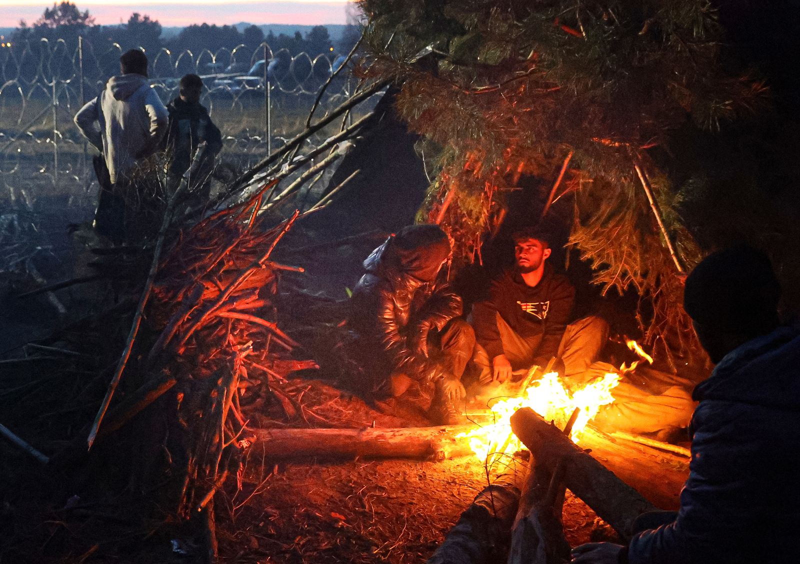 Migranten sitzen am Mittwoch, 10. November, an einem Feuer nahe der polnisch-weißrussischen Grenze. 