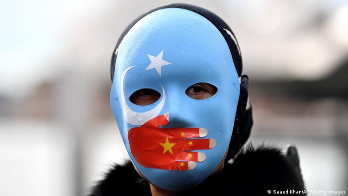 Demonstrant mit Gesichtsmaske nimmt an Protest in Sydney teil und fordert die australische Regierung auf, die Olympischen Winterspiele 2022 in Peking zu boykottieren