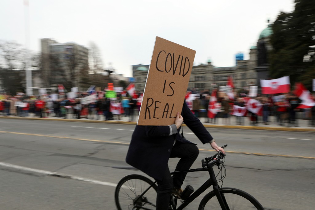 Ein Gegendemonstrant geht in British Columbia an Mandats-COVID-19-Demonstranten vorbei.