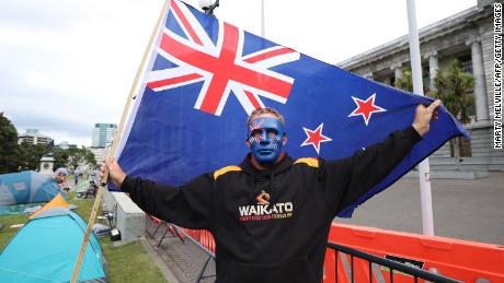 Ein Demonstrant mit einer neuseeländischen Flagge steht am vierten Tag der Proteste gegen die Covid-19-Beschränkungen in Wellington am 11. Februar vor den Parlamentsgebäuden.