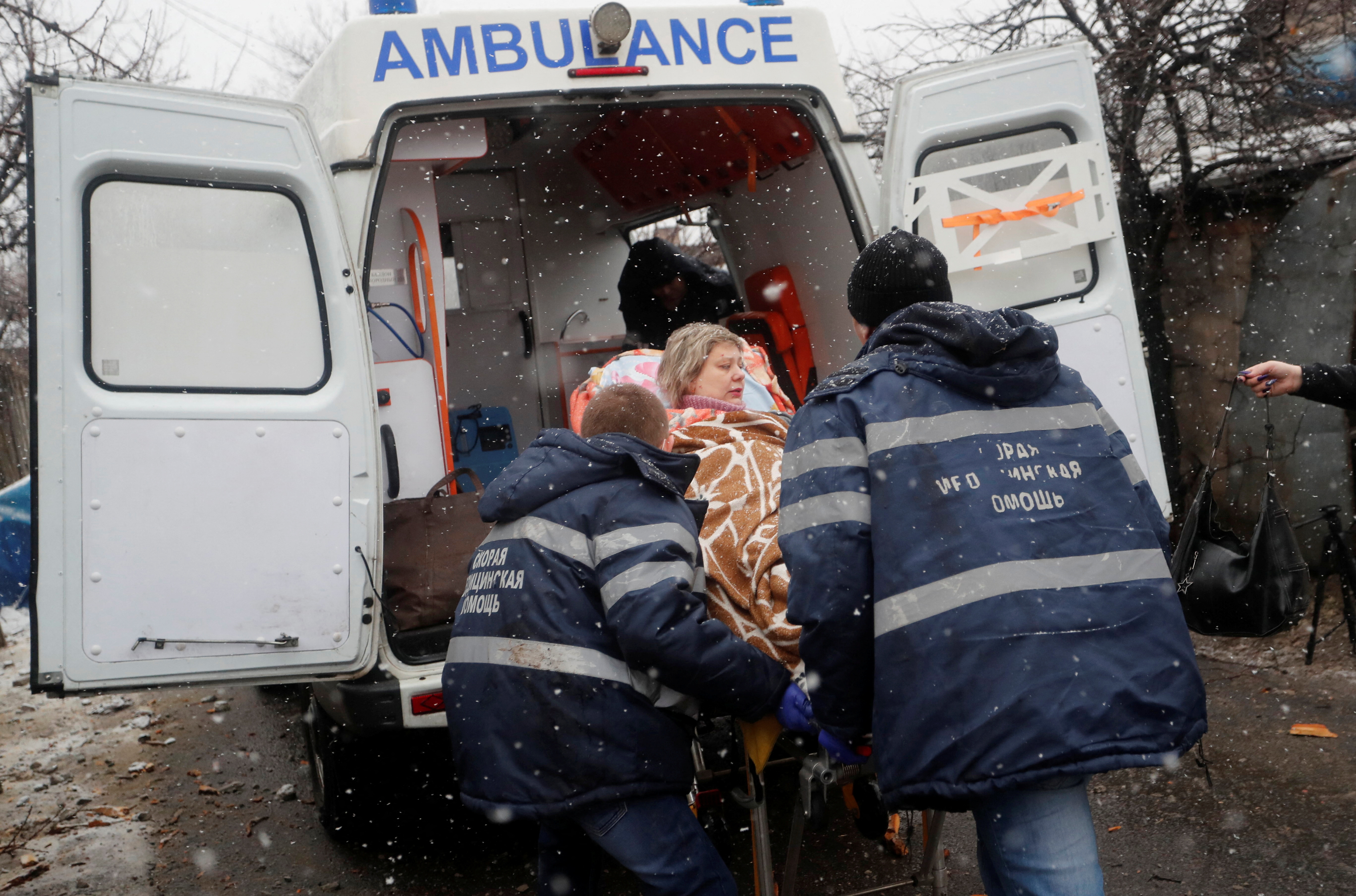 Nach einem kürzlichen Bombenanschlag auf Donezk transportieren medizinische Spezialisten eine verletzte Frau zu einem Krankenwagen