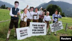 DATEI: Aktivisten der NGO ONE, die Masken tragen, die G-7-Führer repräsentieren, protestieren gegen den G-7-Gipfel, der im bayerischen Alpenhotel Schloss Elmau in Garmisch-Partenkirchen, Deutschland, stattfinden soll.