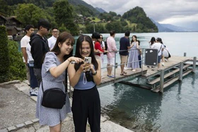 Asiatische Touristen fotografieren auf der Seebrücke in Iseltwald.