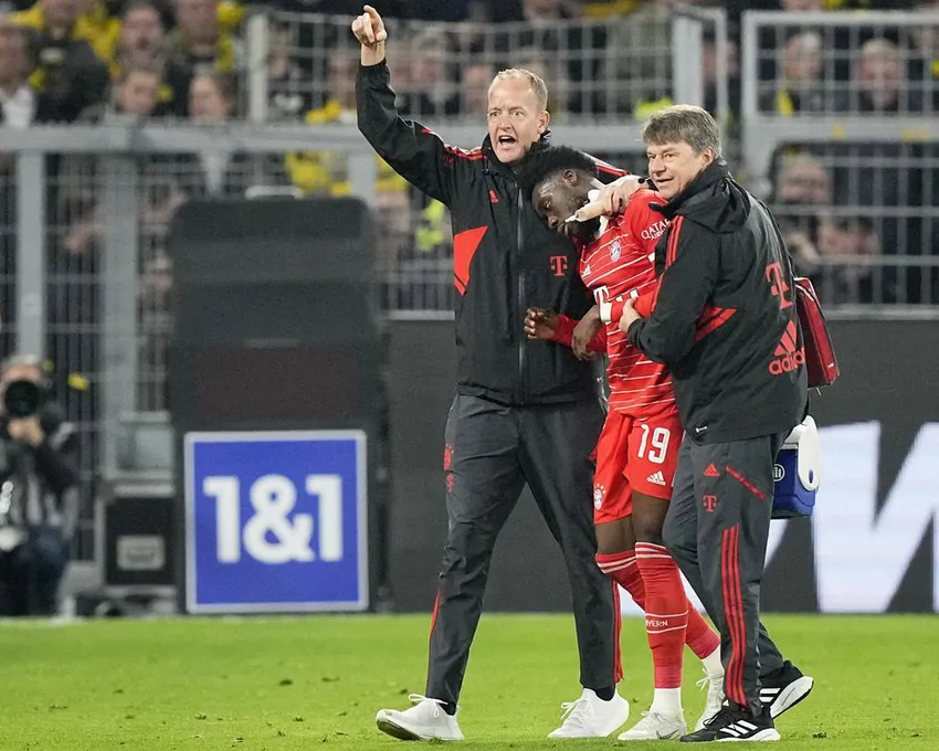 Bayerns Alphonso Davies, Mitte, verlässt das Spielfeld, nachdem er sich beim Bundesliga-Fußballspiel zwischen Borussia Dortmund und Bayern München am Samstag, den 8. Oktober 2022 in Dortmund, Deutschland, eine Verletzung zugezogen hat.