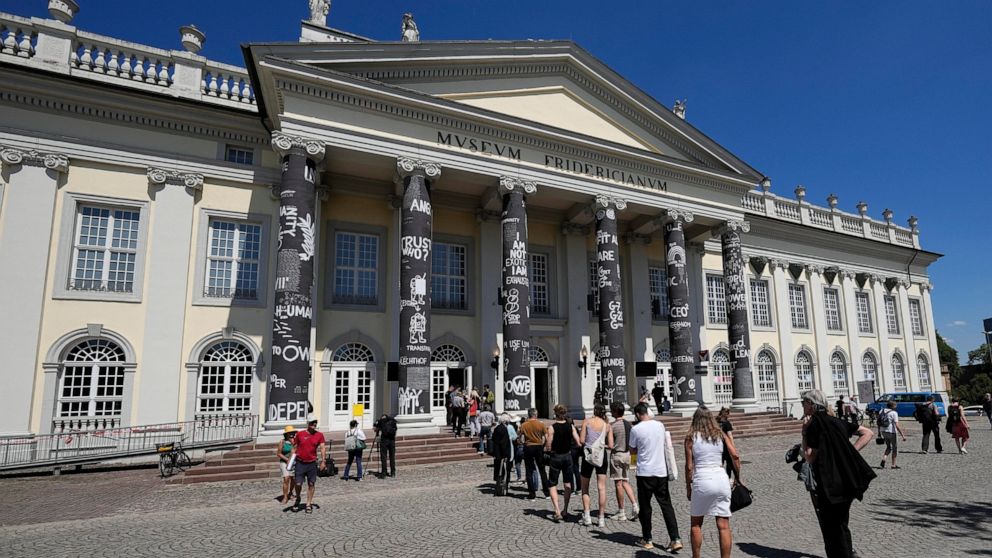 Visitors cue in front of the museum Fridericianum during the press preview of the documenta 15, the world's most significant exhibition of contemporary art, in Kassel, Germany, Wednesday, June 15, 2022. This years documentary is curated by Indonesian